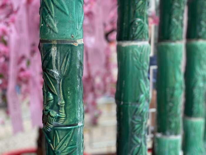 Ceramic pillars outside the temple, which look like green bamboo stalks