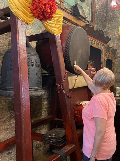 Tourist banging the drum at Man Mo Temple