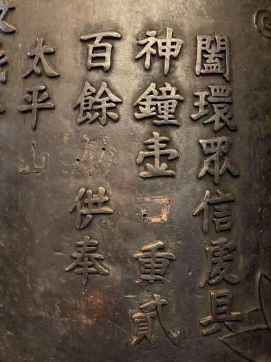 A brass plaque at Man Mo Temple, talking about the garden of God and ringing bells