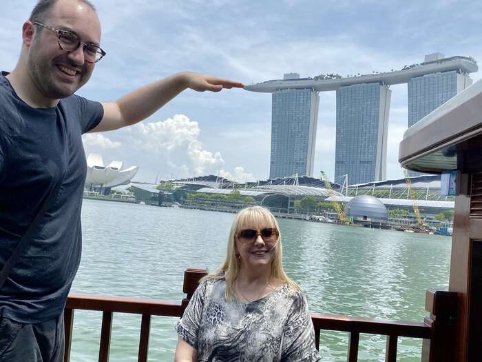 Zarino poses as if he’s touching the top of the Marina Bay Sands hotel